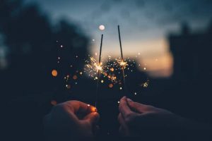 People holding up sparklers and making New Year resolutions